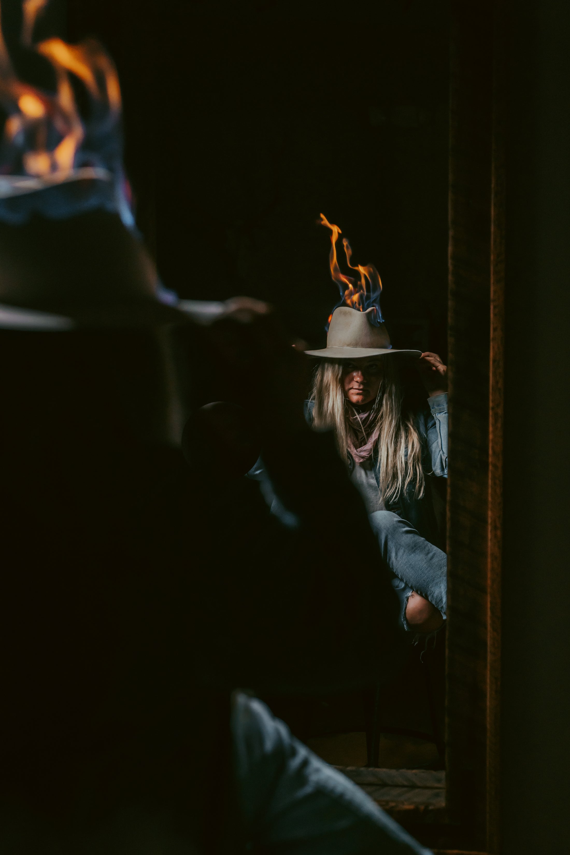 Person wearing a hat with flames in a dimly lit room