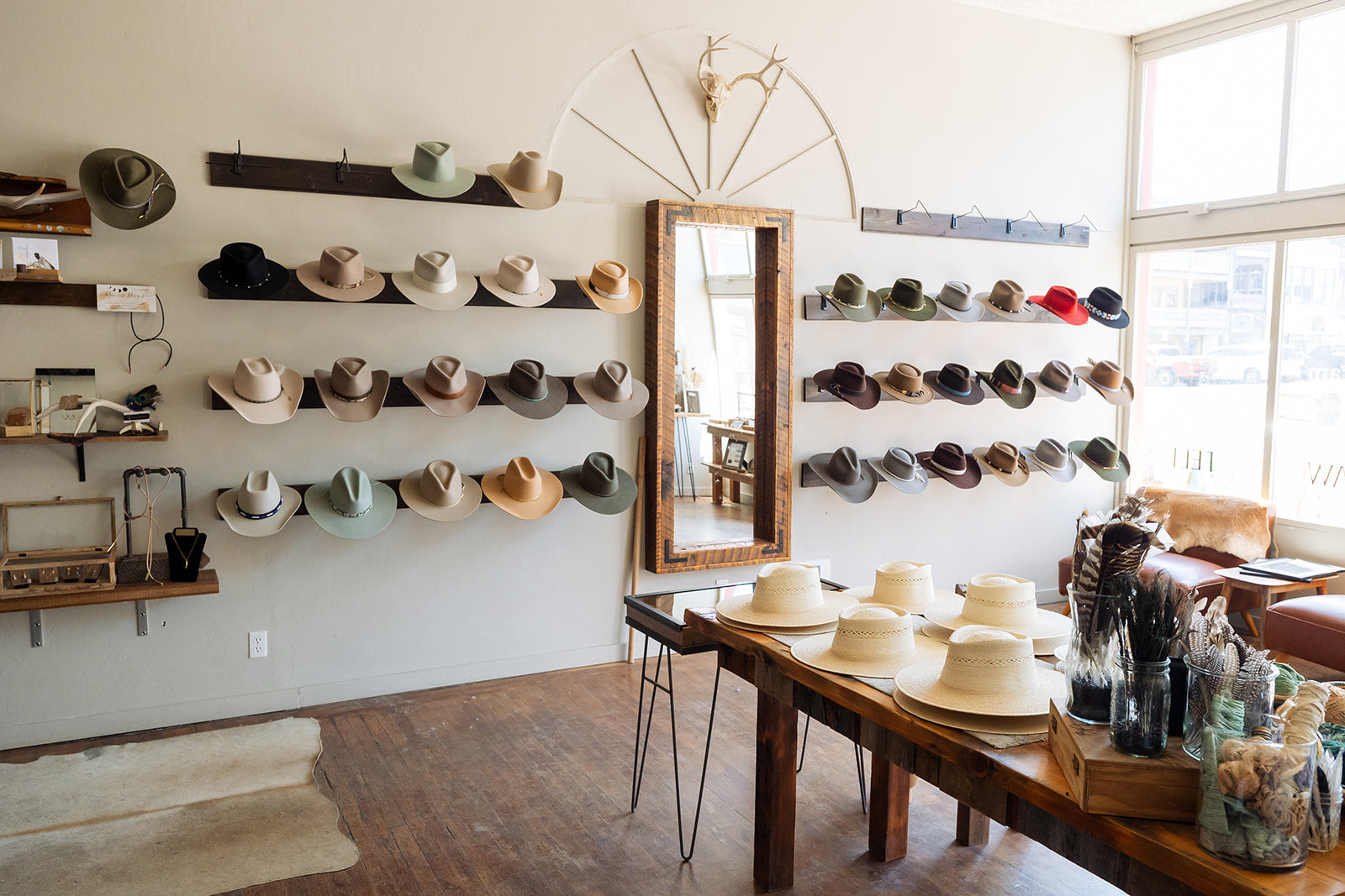Hat store interior with shelves displaying various hats and a wooden table.
