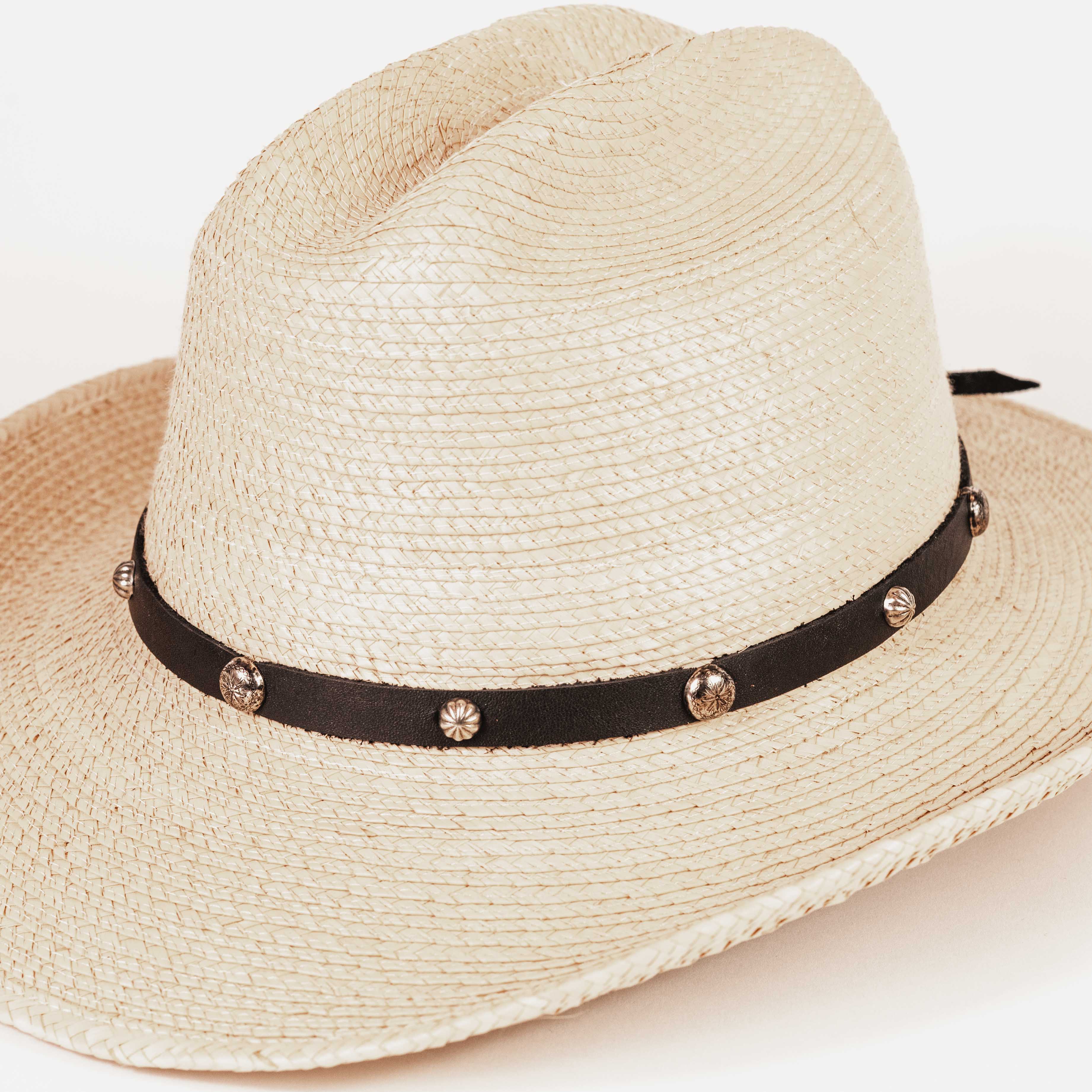 A light beige woven straw fedora hat with a black ribbon band decorated with small metallic studs, shown on a plain white background.
