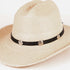 A light beige woven straw western hat with a black band around the crown and three round silver-tone decorative studs, photographed on a clean white background.
