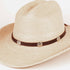 A light beige straw western hat with a dark brown band decorated with three silver-tone conchos, shown against a plain white background.