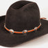 A dark brown felt cowboy hat with a vibrant orange leather band decorated with silver-toned conchos and orange inlays, shown on a clean white background.