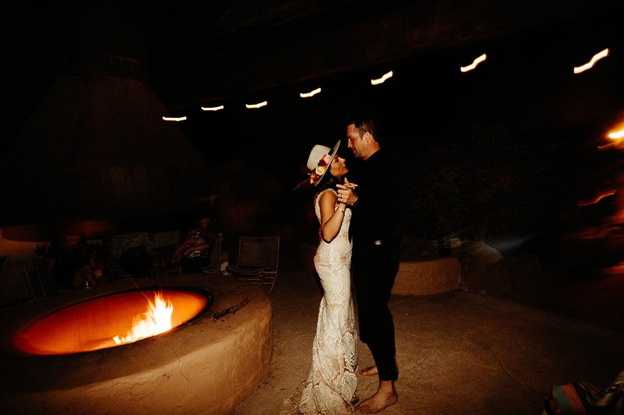 Wedding Couple dancing by the fire in their custom western hat.