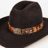 A black felt cowboy hat featuring a decorative band adorned with brown, orange, and gray feathers, set against a plain white background.