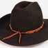 A black felt cowboy hat with a brown leather band tied in a bow and decorated with small silver conchos, shown on a plain white background.