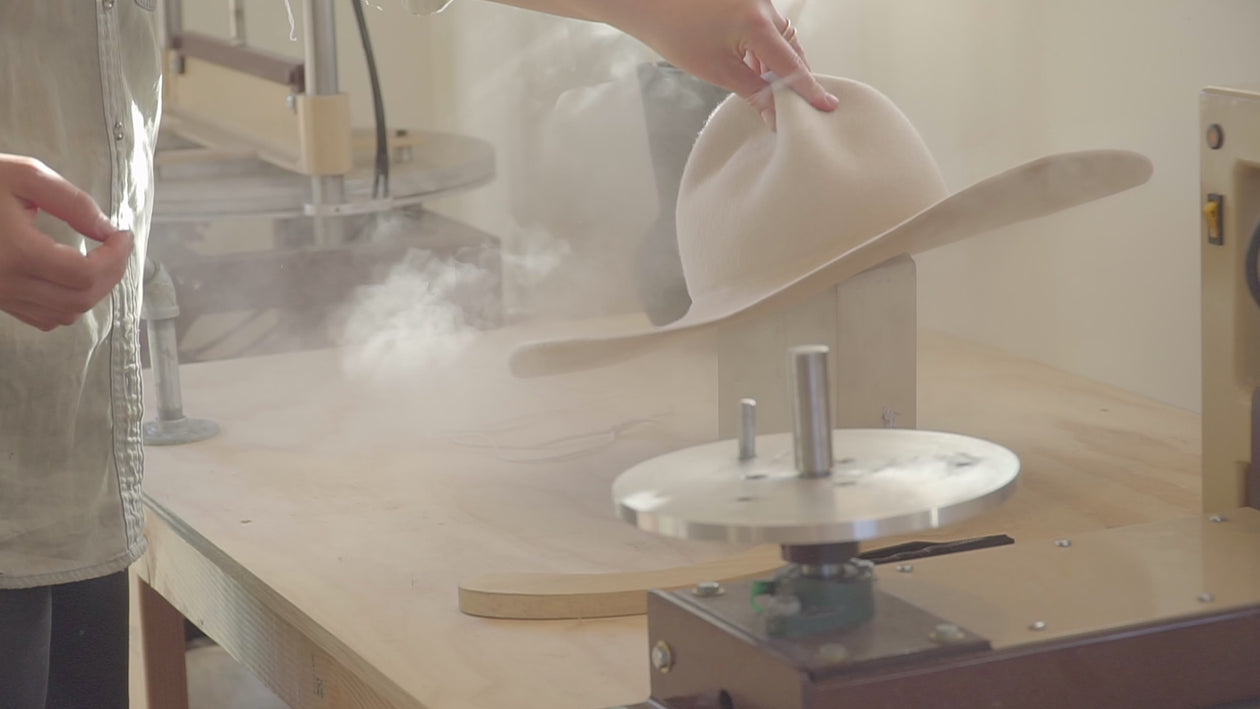 Process of a western hat being made with steam, sanding, blocking in a workshop.